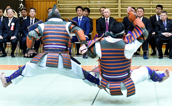 Премьер-министр Японии Синдзо Абэ и президент России Владимир Путин (слева направо на втором плане) во время посещения центра восточных единоборств «Кодокан»
