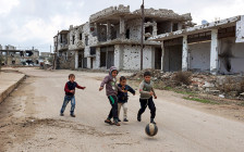 Дети играют возле разрушенных зданий в сирийском городе ​Босра Аль-Шам


