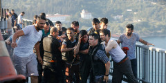 Полицейские защищают причастного к мятежу военного  на мосту через Босфор


