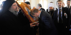 Президент России Владимир Путин кланяется перед иконой Вседержителя при посещении Кареи, административного центра Афона
