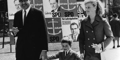 Глава федеральной земли Рейнланд-Пфальц Гельмут Коль со своей первой женой Ханнелорой Коль и сыном проходят мимо избирательных плакатов социал-демократов в Людвигсхафене. 8 июня 1969 года.
