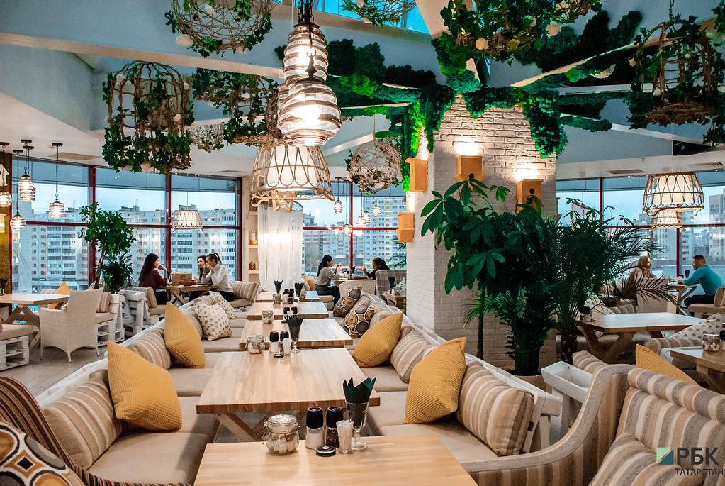 Интерьер ресторана выполнен в экологическом стиле со множеством живых растений