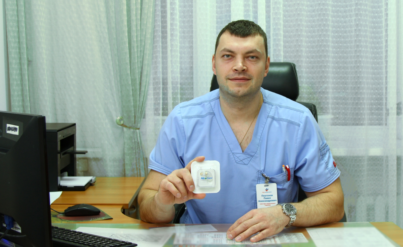 Павел Платонов, врач-хирург держит в руках упаковку с эндоскопической капсулой