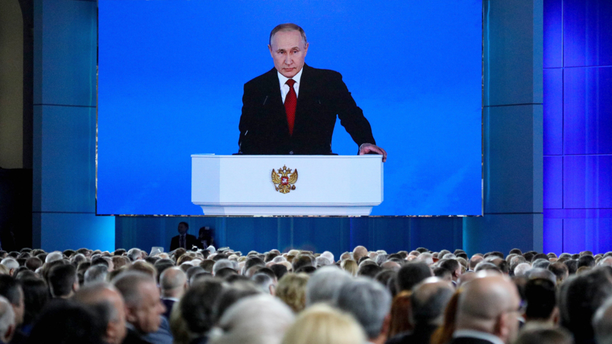 Владимир Путин (на экране) во время выступления с ежегодным посланием к Федеральному Собранию РФ