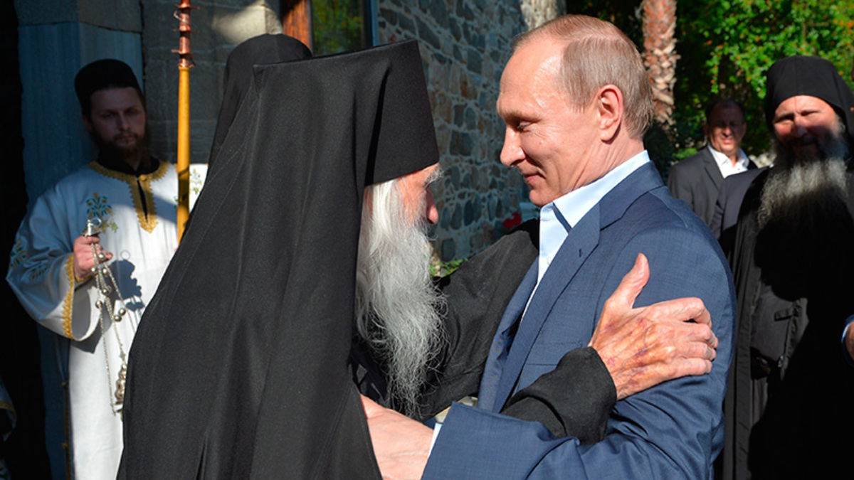 Владимир Путин и схиархимандрит Иеремия приветствуют друг друга в храме Успения Пресвятой Богородицы в Карее, административном центре Афона