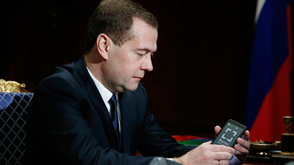 Председатель правительства РФ Дмитрий Медведев рассматривает смартфон с жидкокристаллическим экраном, продемонстрированный генеральным директором Государственной корпорации «Ростехнологии» Сергеем Чемезовым, 2013 год