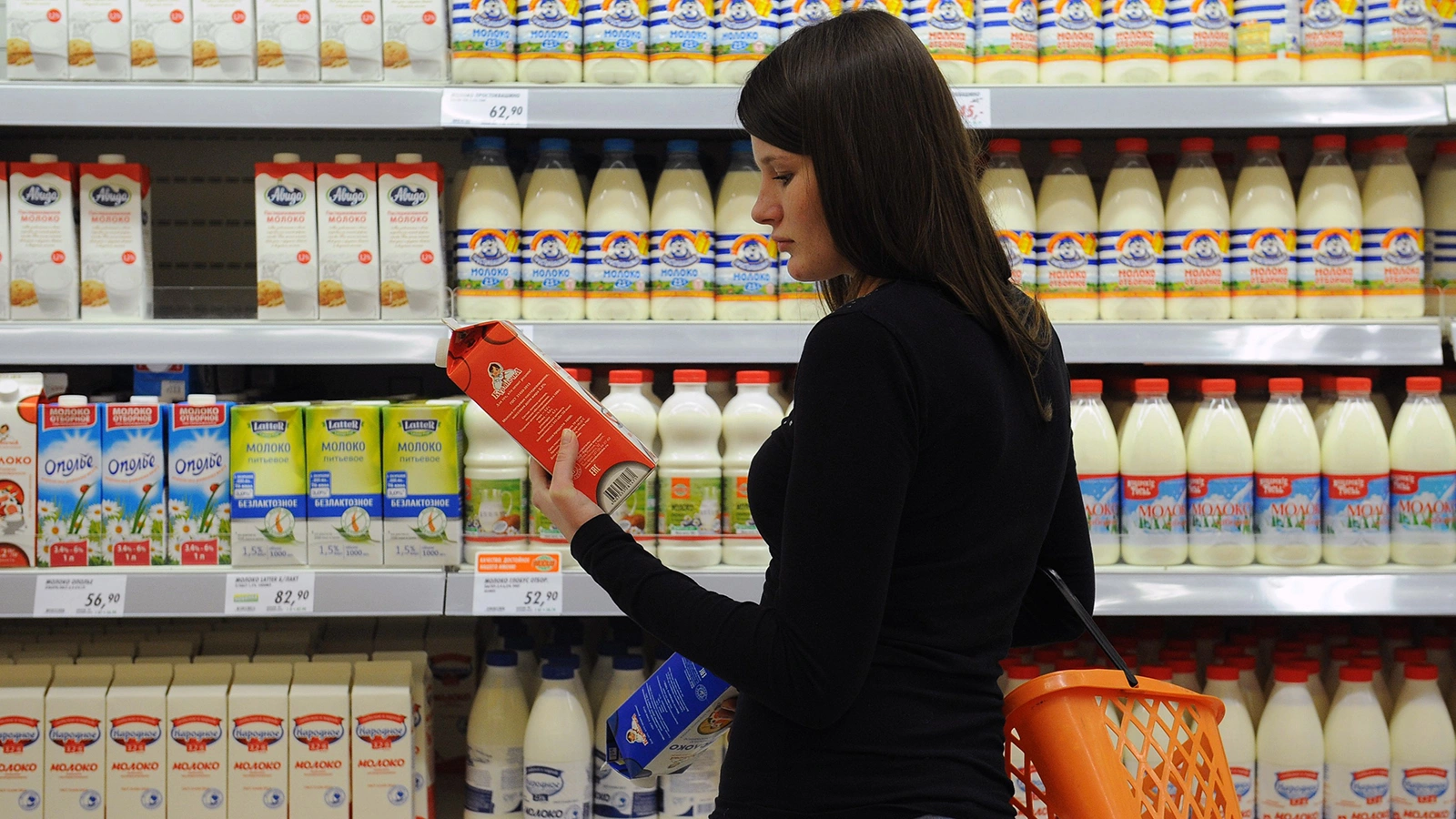 <p>Покупательница выбирает молоко в супермаркете</p>