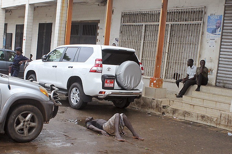 Полиция Конакри (Гвинея) огородило место, где упал человек, предположительно больной лихорадкой. Мужчина пролежал на асфальте несколько часов до того, как его отправили в центр Эбола для диагностики. 