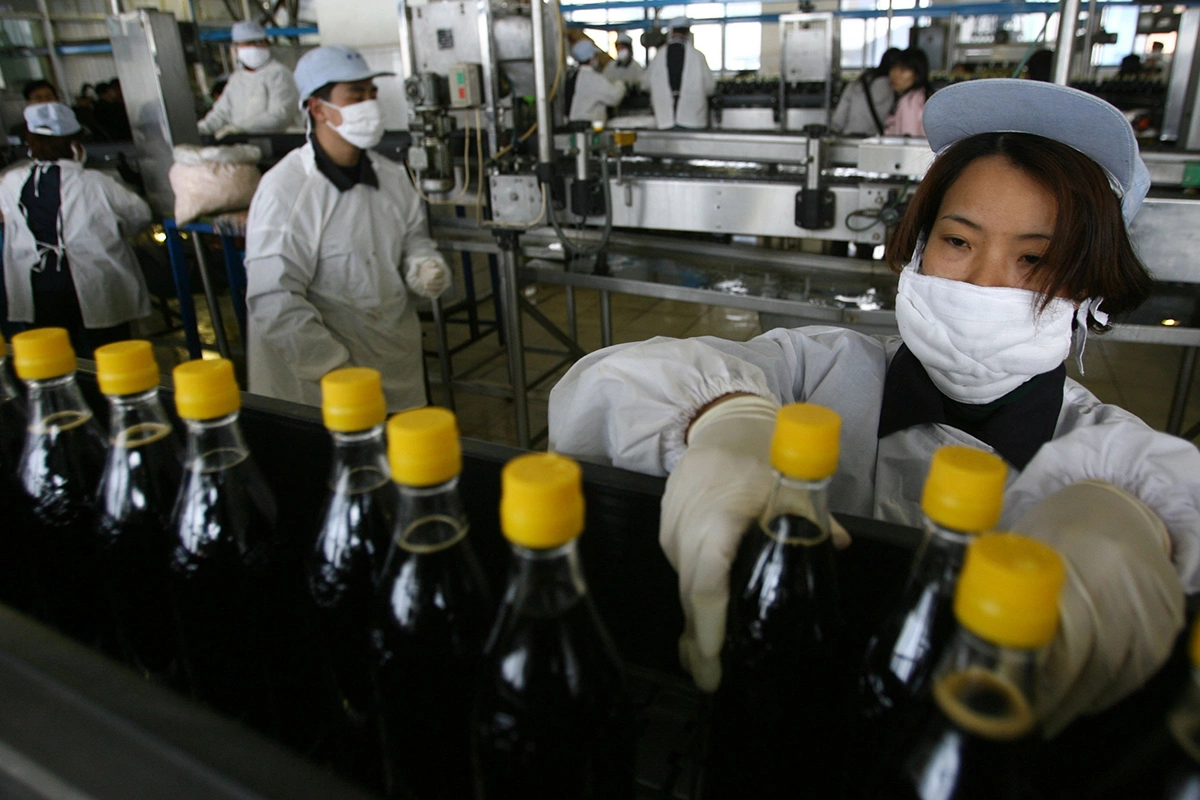 Женщина на производственной линии уксусного завода в Чжэньцзяне, провинция Цзянсу, Китай