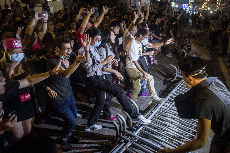 Сторонники свободных выборов ломают полицейские заграждения в районе Монгкок 18 октября.