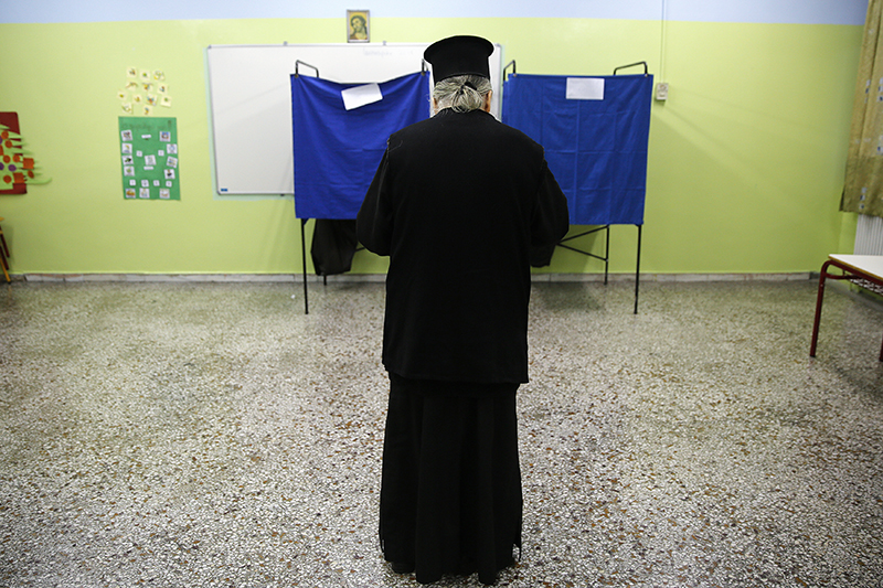 Греческий православный священник собирается проголосовать.