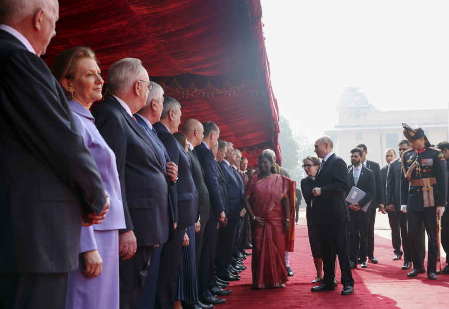 Владимир Путин и президент Индии Драупади Мурму (в центре) приветствуют&nbsp;российскую делегацию на церемонии официальной встречи.