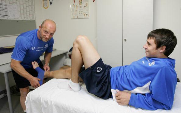 Спортивный врач помогает игроку