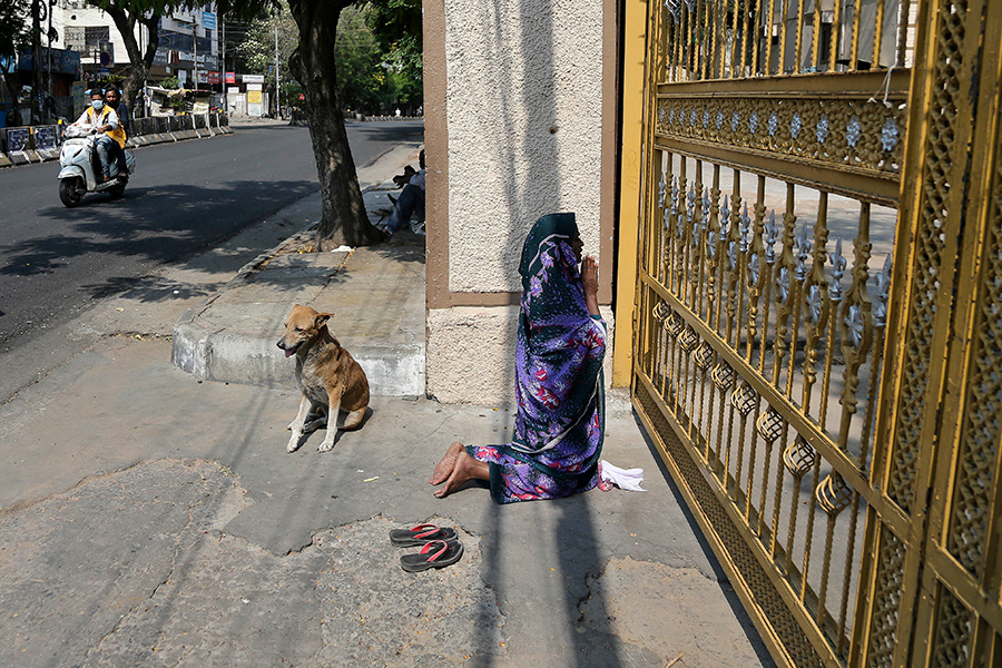 Индийская женщина молится у закрытых ворот базилики Святой Марии в Хайдарабаде, Индия. По всему миру люди празднуют Пасху дома для того, чтобы помочь сдержать распространение вируса
