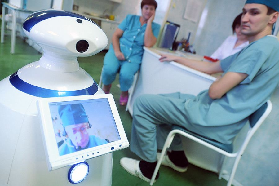 R.Bot 100 &mdash; устройство телеприсутствия со встроенными видеокамерами и микрофоном. Этот мобильный робот помогает врачам следить за состоянием пациентов с помощью управления через интернет.

​На фото: R.Bot 100 в военном клиническом госпитале им. Вишневского
