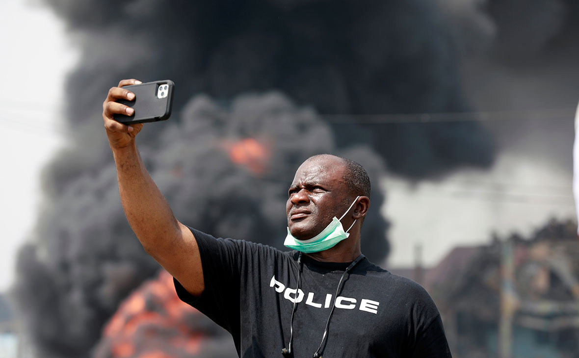 Полицейский делает снимок на месте взрыва трубопровода в Абуле-Адо