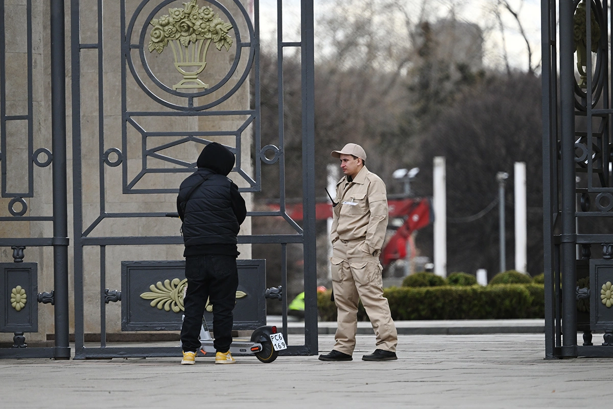 <p>Мужчина разговаривает с охранником у входа в парк Горького. Из-за сильного ветра парки города временно закрыты для посетителей</p>