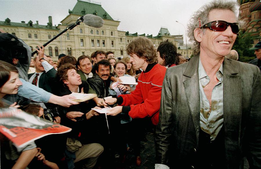 Мик Джаггер раздает автографы, а Кит Ричардс улыбается во время прогулки по Красной площади у Кремля в Москве, 10 августа 1998 года