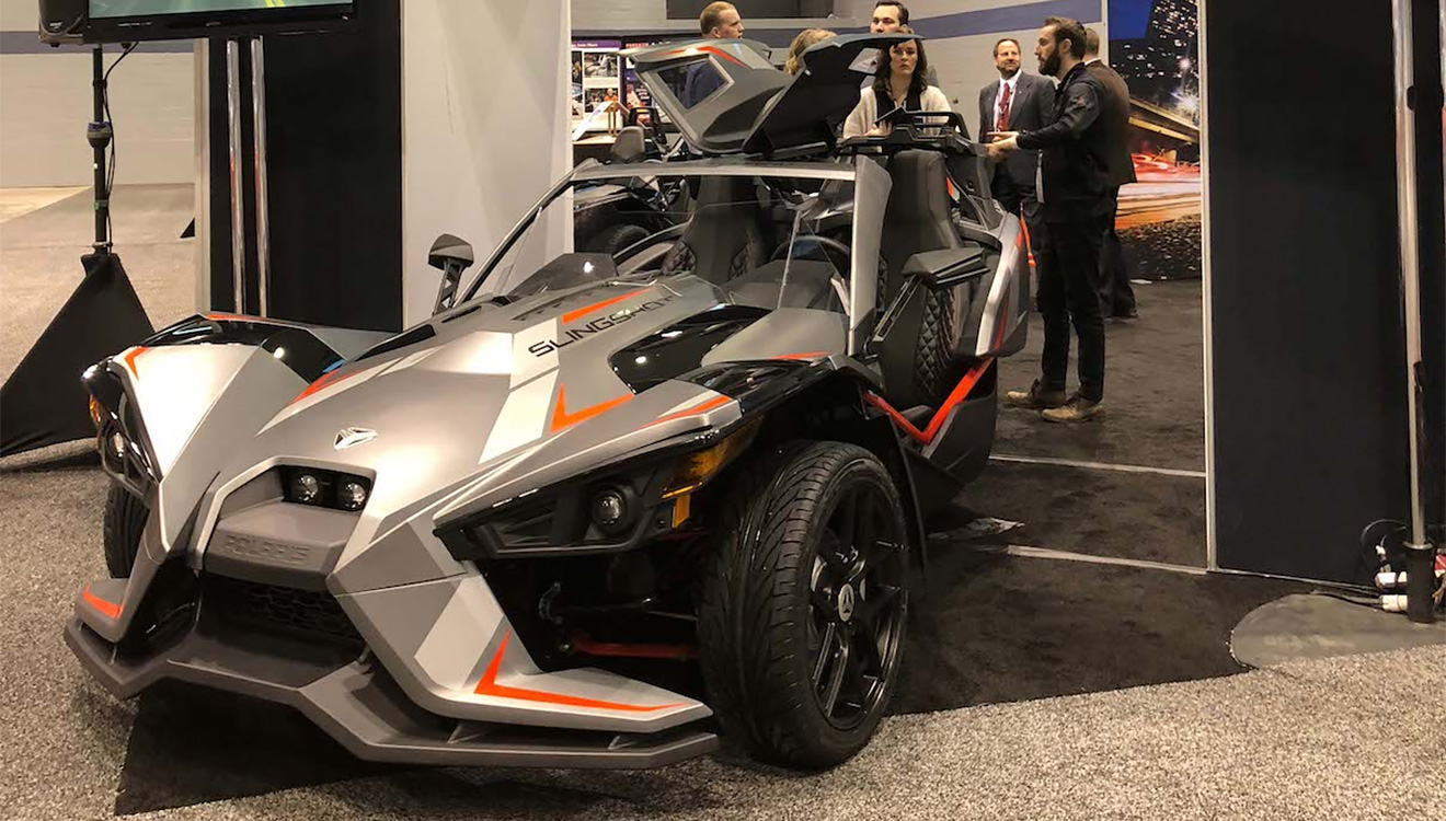 В США нет единого мнения, какие права нужны на Polaris Slingshot &mdash; автомобильные и мотоциклетные. У него автомобильные кресла и руль, 4-цилиндровый мотор 2,4 л (175 л.с.), но водитель и пассажир открыты всем ветрам и вынуждены ездить в шлемах. Для дальних поездок создана версия Grand Touring LE с крышей, ветровым щитком, навигатором и аудиосистемой.
