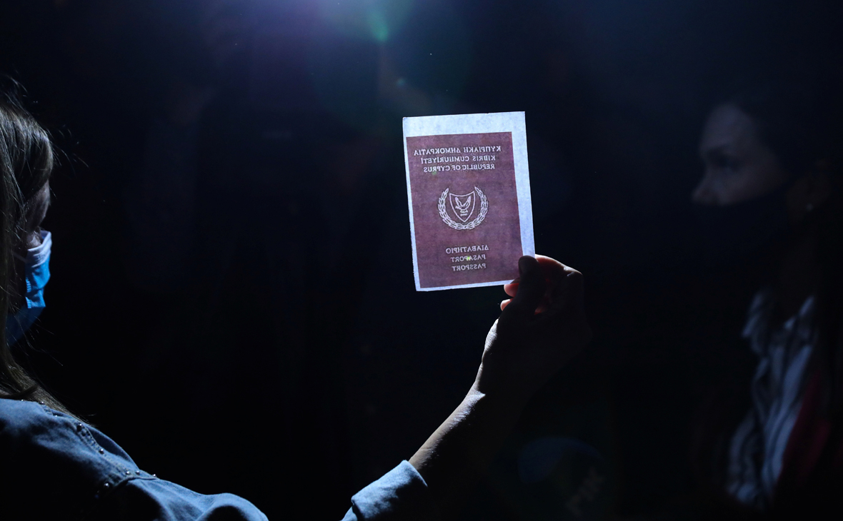 Человек держит изображение паспорта во время акции протеста против коррупции