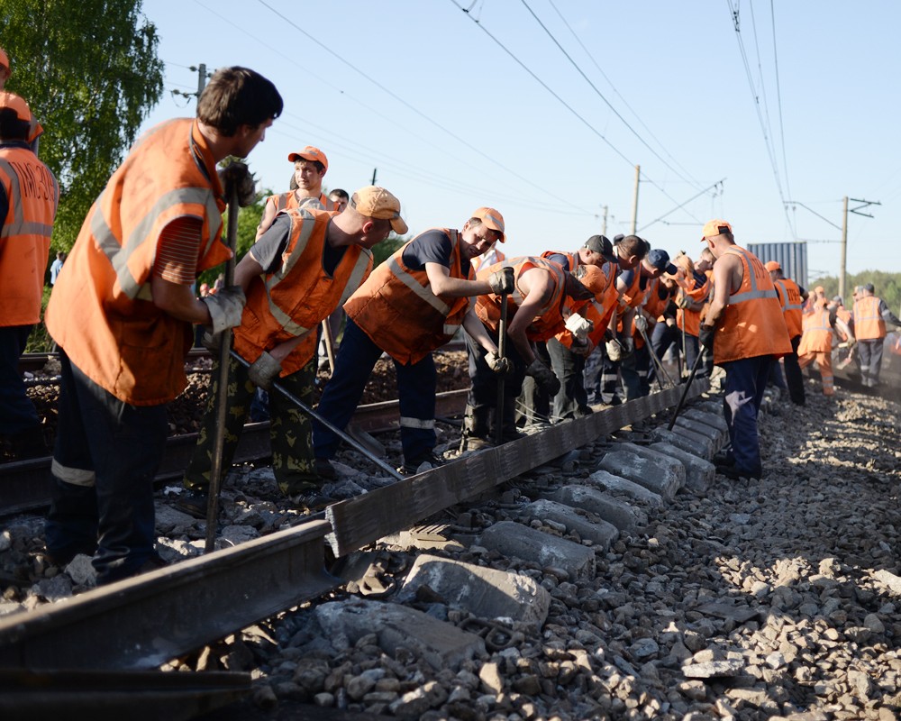 Путевые рабочие ремонтируют железнодорожное полотно 