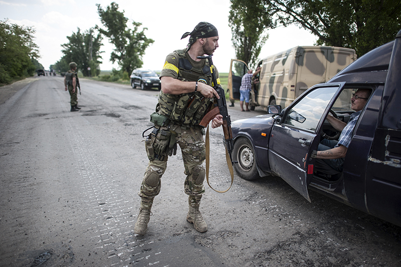 Украинский военнослужащий из&nbsp;батальона &laquo;Киев 1&raquo; досматривает проезжающие машины недалеко от&nbsp;Марьинки.