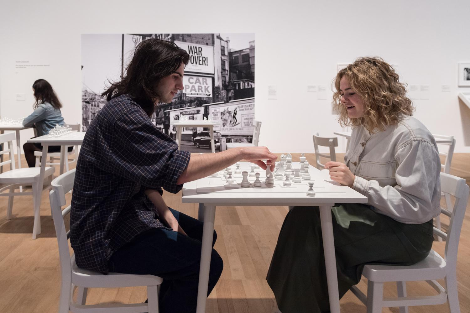 Посетители играют в белые шахматы (&laquo;White Chess Set&raquo;, 1966) на выставке Yoko Ono: Music Of The Mind в галерее Tate Modern