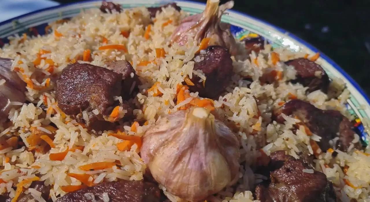 Переложите плов на сервировочное блюдо