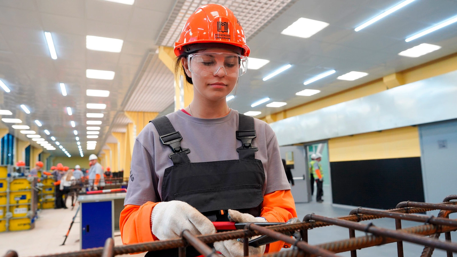 Студентка по специальности «Строительство и эксплуатация инженерных сооружений» отрабатывает навыки возведения опалубки в мастерской бетонных строительных работ