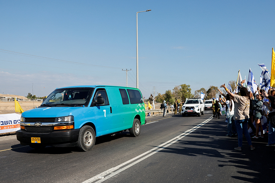 На фото: автоколонна с заложниками приезжает в Реим, Израиль.