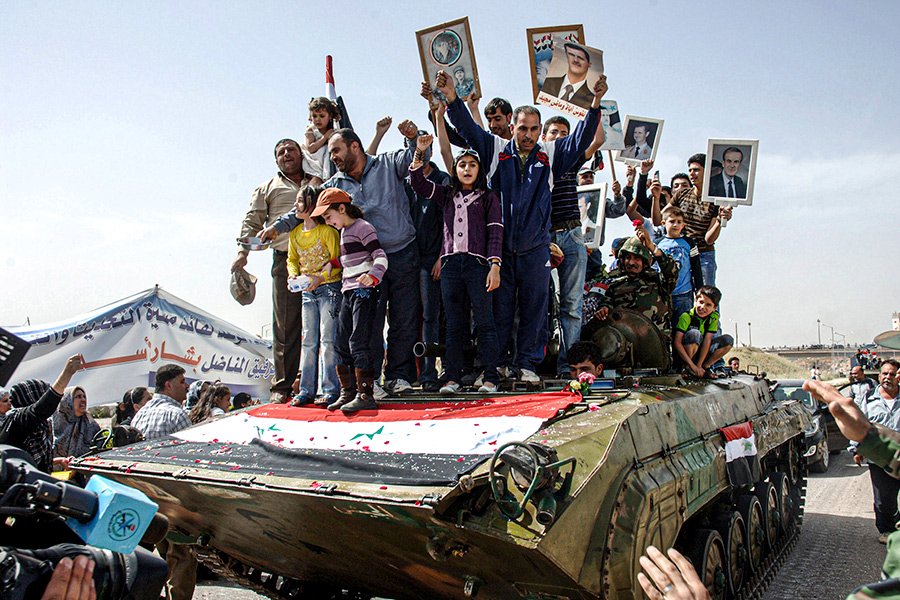 Сторонники правительственных сил с плакатами во время вывода правительственных войск из Дераа, 5 мая 2011 года