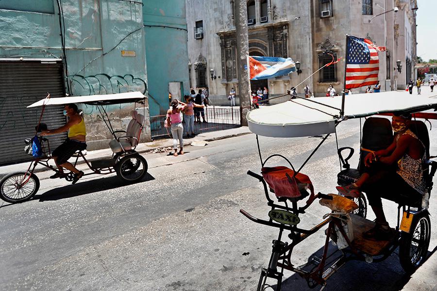 Велорикша, украшенный флагами Кубы и США, в Гаване