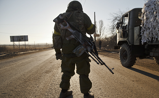 Украинский военнослужащий стоит на дороге за пределами Артемовска, 18 февраля 2015 год