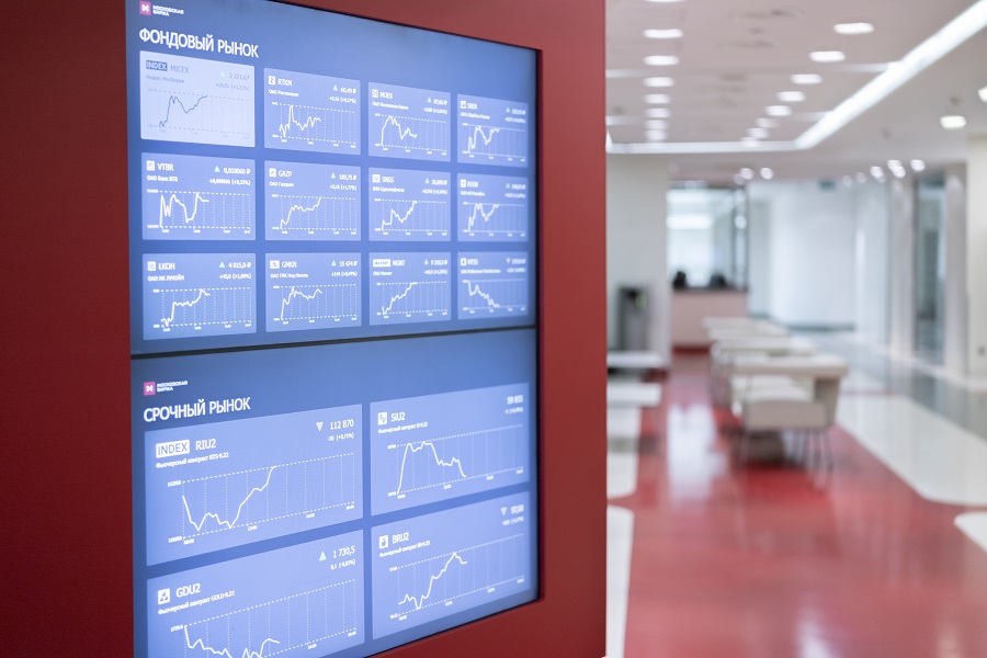Информационный стенд с графиками фондовых и валютных рынков в офисе Московской биржи на Воздвиженке в Москве