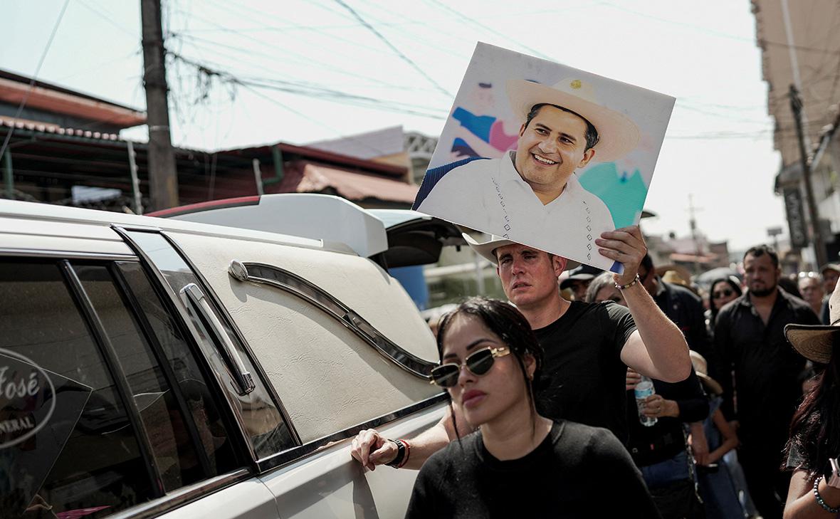 Мужчина держит фотографию Карлоса Манcо,&nbsp;застреленного во время мероприятия в День мертвых в Уруапане, Мексика
