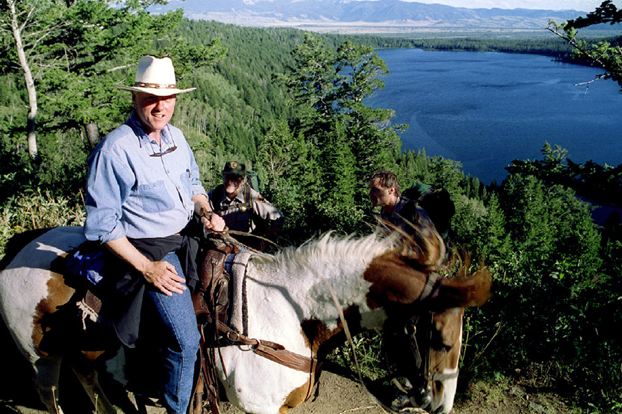 Президент США Билл Клинтон добирался на коне к месту отдыха на природе с семьей в августе 1995 года. На этом фото он находится неподалеку от озера Фелпс в штате Вайоминг​
