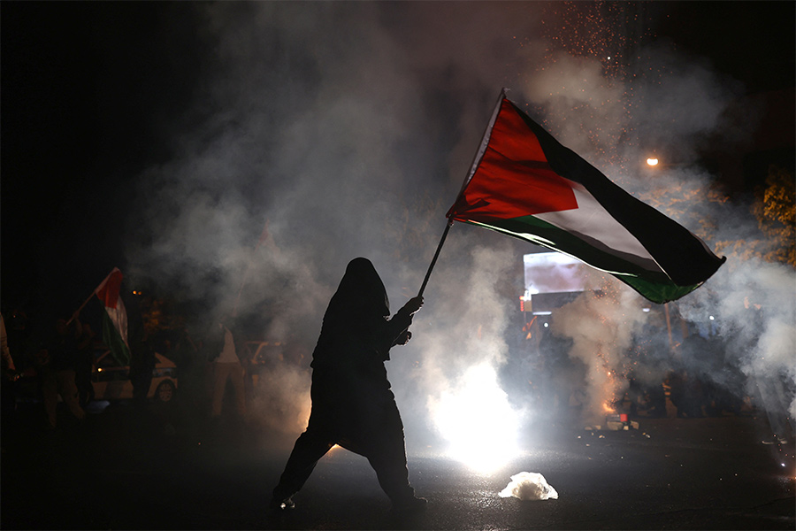 Женщина с палестинским флагом на акции в поддержку Палестины в Иране.