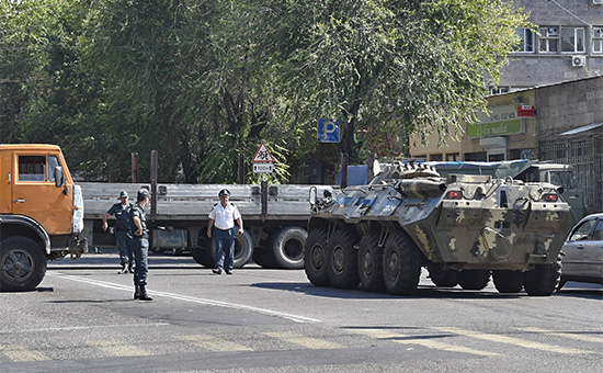 Полиция блокирует улицу грузовиками бронетранспортером&nbsp;(БТР) перед началом спецоперации по освобождению заложников из захваченного здания отделения полиции в районе Эребуни на окраине Еревана


