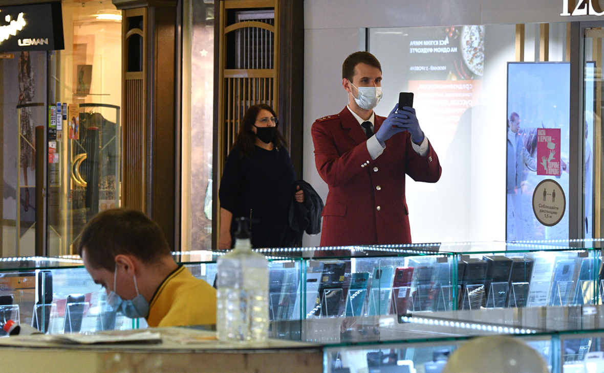 Сотрудник Роспотребнадзора (справа) проверяет соблюдение масочного режима в торговом центре &laquo;Охотный ряд&raquo; в Москве