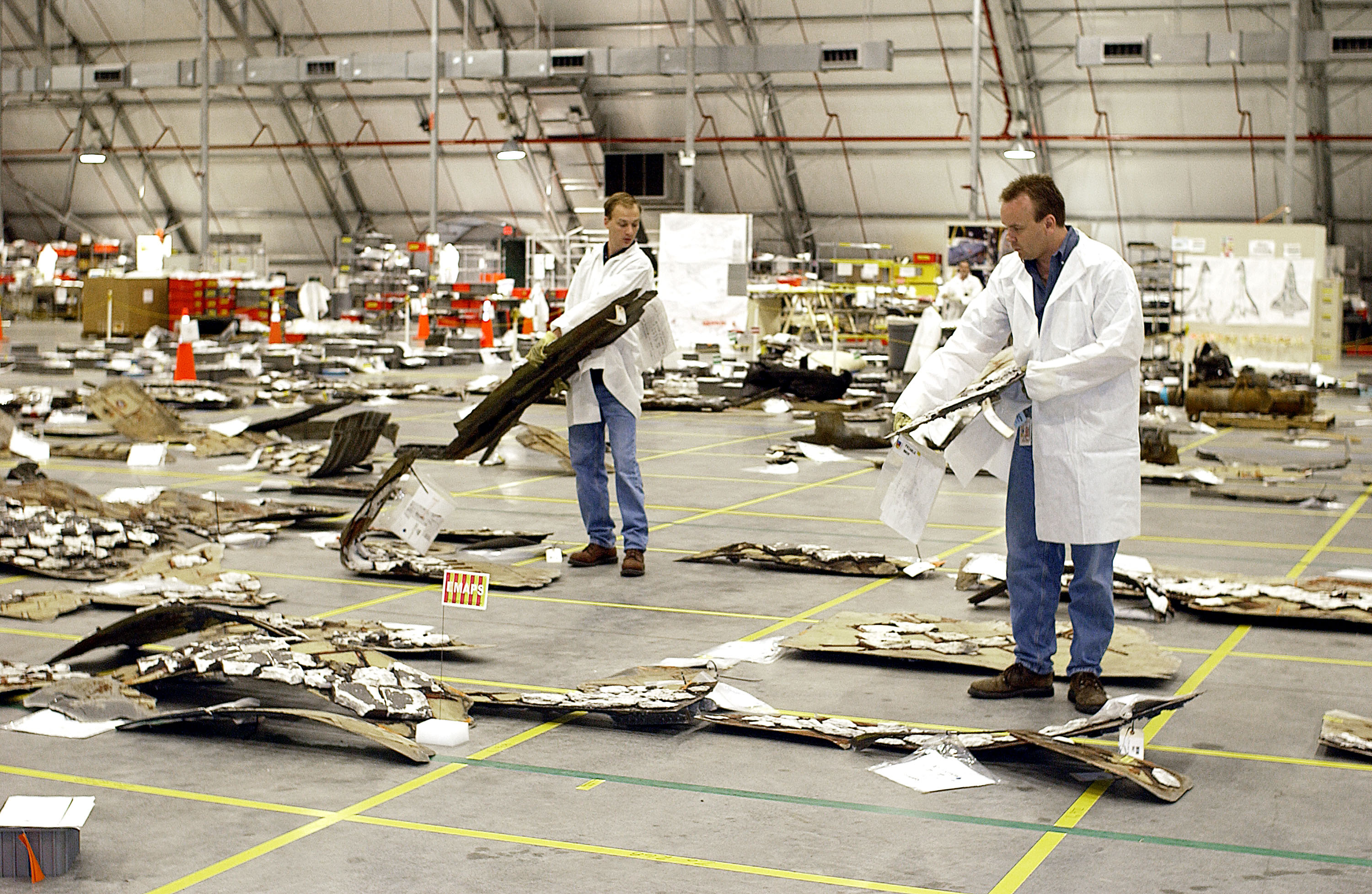 Обломки &laquo;Колумбии&raquo; сортируются на складе и раскладываются в модель шаттла. Космический центр имени Кеннеди, Флорида, США. апрель 2003.