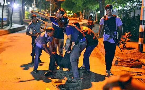 Полицейские и простые граждане помогают раненому при захвате ресторана террористами в Дакке


