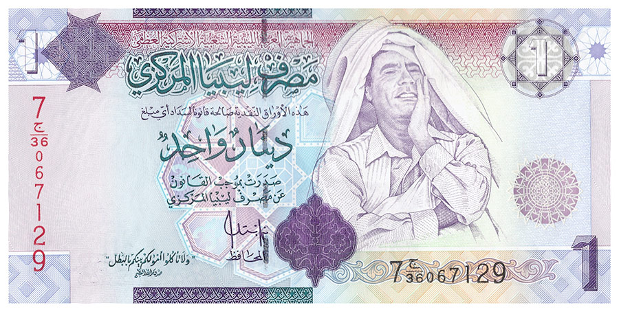 Впервые портрет &laquo;вождя ливийской революции&raquo; Муаммара Каддафи появился в 1993 году на купюре в один ливийский динар. Позже &mdash; на банкноте в 20 динаров, на оборотной стороне которой Каддафи можно было увидеть в окружении лидеров африканских государств. В 2008 году в Великобритании отпечатали самые крупные из ливийских банкнот достоинством в 50 динаров, на которых ливийский лидер был изображен в своих знаменитых темных очках.

Портреты &laquo;вождя ливийской революции&raquo; не потеряли своей цены и после того, как его режим окончательно рухнул в результате гражданской войны, а сам Каддафи в октябре 2011 года был убит. Старыми купюрами, какими&nbsp;бы идеологически неправильными они ни были, продолжали платить зарплаты и налоги. Новые начали появляться в обращении лишь в 2013 году.

Каддафи возглавил Ливию в 1979 году, свергнув монархию. В стране был установлен новый режим &mdash; &laquo;джамахирия&raquo; (приблизительный перевод &mdash; республика масс). Были отменены традиционные институты власти, управление возложено на народные комитеты и народные конгрессы, которые управляли общинами &mdash; самоуправляемыми мини-государствами в государстве, обладающими всей полнотой власти в своем округе, включая распределение бюджета. В народный конгресс входили все жители общины. Высший законодательный орган &mdash; Всеобщий народный конгресс (ВНК). ВНК был уполномочен избирать свой постоянный орган &mdash; Генеральный секретариат, формировать Высший народный комитет (правительство). Система джамахирии исключала деятельность вообще любых политических партий, в стране отсутствовала конституция. В 1972 году в Ливии&nbsp;были введены некоторые нормы&nbsp;шариата. В 1977 году Коран объявлен &laquo;законом общества&raquo;. Регулярная армия и полиция были заменены на &laquo;вооруженный народ&raquo; и &laquo;народную милицию&raquo;.

Одним из достижений правления Каддафи стало то, что часть доходов от нефтедобычи была&nbsp;направлена&nbsp;на социальные нужды. К середине 1970-х годов началась масштабная программа строительства жилья, развивалось здравоохранение и образование. С другой стороны, Ливию в период правления Каддафи неоднократно обвиняли во вмешательстве в дела зарубежных государств. В 1977 году страна участвовала в военном конфликте с Египтом, в 80-х &mdash; в гражданской войне в Чаде. Самого Каддафи обвиняли в спонсорстве национально-освободительных, революционных и террористических организаций по всему миру. В 1990-х годах США ввели санкции против Ливии.

В 2011 году Каддафи был убит во время гражданской войны, продолжающейся в Ливии до сих пор.
