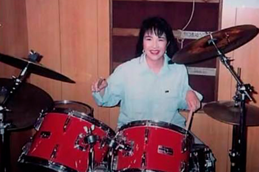 Такаити, которая в юности увлекалась хеви-металом, за ударной установкой