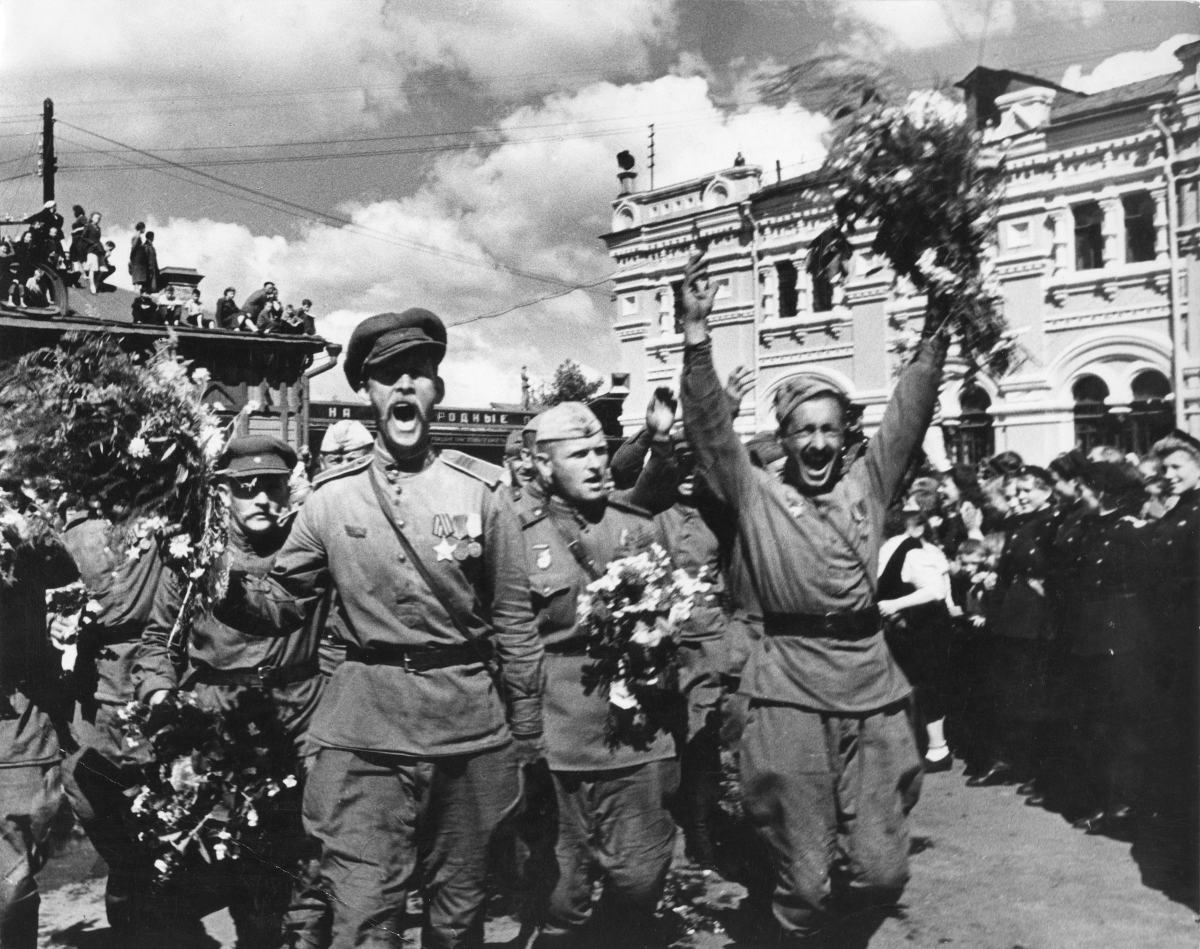 Москва. Встреча советских солдат-победителей у Ржевского (современного Рижского) вокзала.
Но не все с фронта возвращались домой. Из-за готовящейся войны с Японией эшелоны массово с запада сразу отправляли на восток. Например, советский писатель Владимир Бушин писал в своем дневнике 4 июня 1945 года: «Назревает большое событие для роты: мы куда-то едем. Вся армия остается на месте, а мы едем. Уже заготавливают на месяц продуктов, договариваются о вагонах, упаковывают, ремонтируют… Неизвестно только — куда. Есть слух, что на Дальний Восток. Я не верю, надеюсь, поедем не дальше Москвы. Конечно, хорошо бы из этой Пруссии вернуться в Россию».
После Дня Победы Бушина с сотоварищами отправили в Маньчжурию воевать с японскими солдатами. Он вернулся в Москву только в 1946 году.