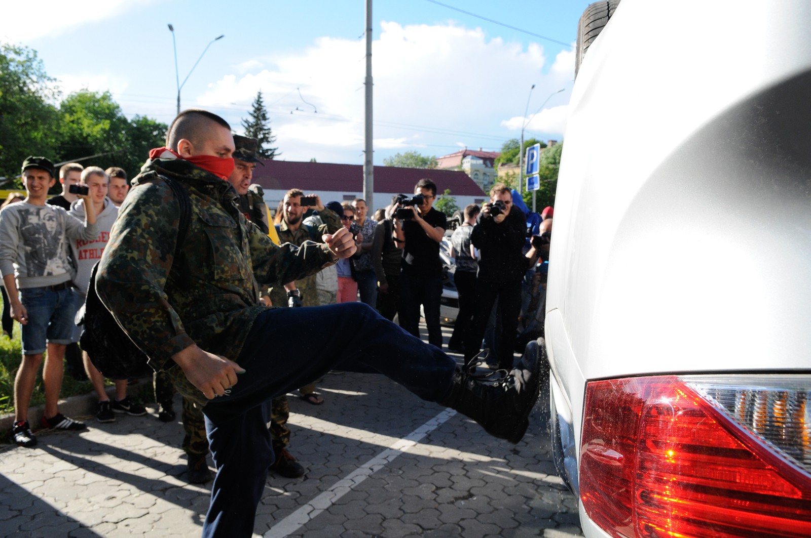 Представители националистических организаций переворачивают автомашины во время устроенных ими беспорядков у посольства России в Киеве.