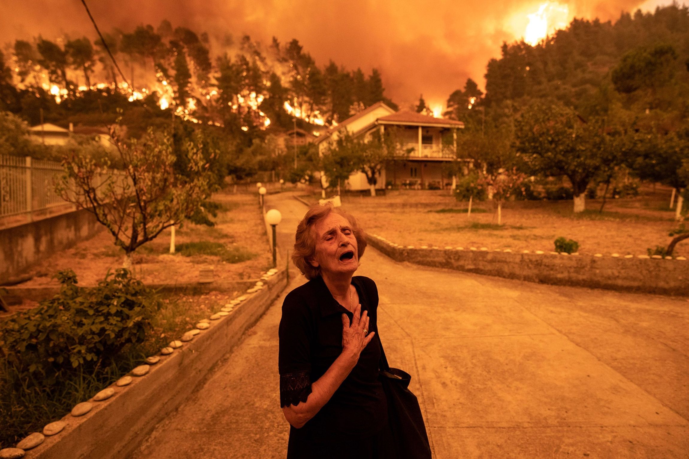 8 августа. Греция. Женщина, вынужденная покинуть свой дом из-за лесных пожаров на острове Эвбея