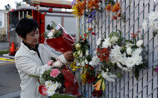 Женщина несет цветы к месту пожара


