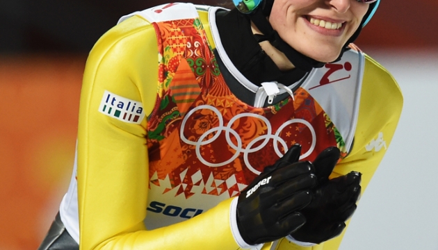 Итальянка Evelyn Insam улыбается во время соревнований в прыжках со среднего трамплина среди женщин