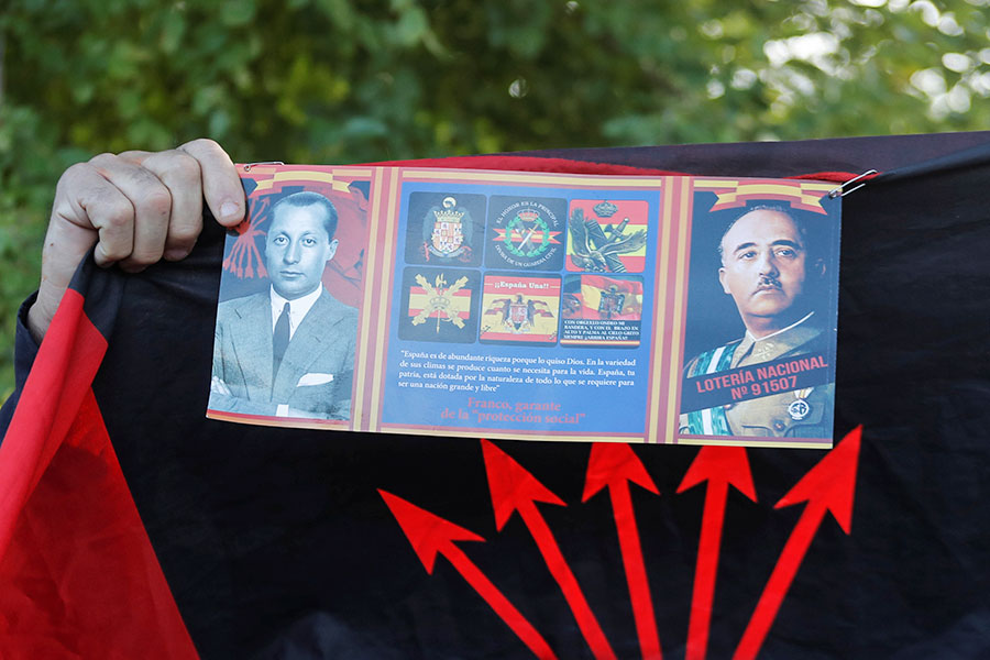 К Долине Павших приехали последователи Франко. На фото один из них держит фотографию диктатора&nbsp;(справа) и флаг &laquo;Фаланги&raquo;&nbsp;&mdash; правой партии, правившей в стране при франкистском режиме

