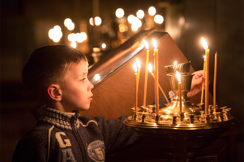 Ребенок во время рождественского богослужения в Крестовоздвиженском соборе в Омске